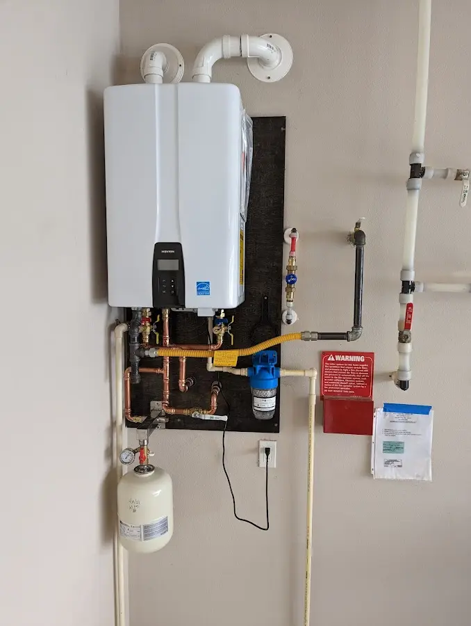 Professional plumber installing copper piping in a Mebane home